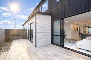 ein Haus mit Glasschiebetüren und einem Wohnzimmer in der Unterkunft Modern 4-Bedroom Home in Silverdale in Silverdale