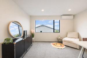 ein Wohnzimmer mit einem Spiegel und einem Stuhl in der Unterkunft Modern 4-Bedroom Home in Silverdale in Silverdale + 17 Fotos