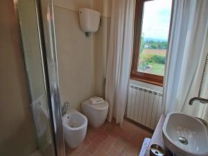 een badkamer met toilet, wastafel en raam bij Modern holiday home in Foligno - Loc with pool in Case Vecchie