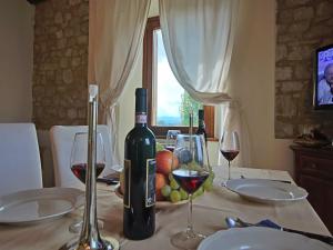 een fles wijn op een tafel met wijnglazen bij Modern holiday home in Foligno - Loc with pool in Case Vecchie +26 foto's