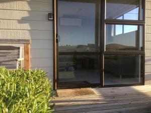 a sliding glass door on the side of a house at South Catlins Cottage in Tokanui