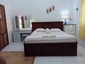 a bedroom with a large bed and a mirror at Wambuliga Homestay in Waha +148 photos