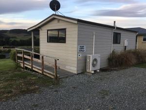 a small building with a porch and a transmitter at South Catlins Cottage in Tokanui +1 photo