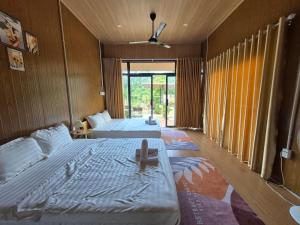 a bedroom with two beds and a window at Cây Trôm Homestay 1 in Vĩnh Hy