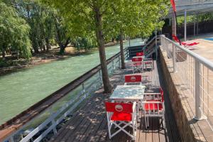een rij tafels en stoelen op een terras naast een rivier bij Hostel Valle Grande in San Rafael