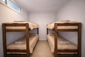 2 stapelbedden in een kleine kamer met een raam bij Hostel Valle Grande in San Rafael