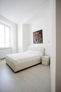 a white bedroom with a bed and a painting on the wall at Alberica10 in Carrara