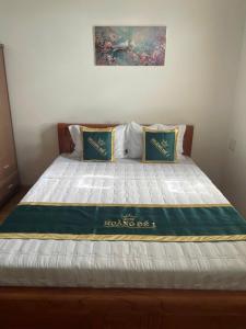 a bed with a blue and white blanket on it at Motel hoàng đế 1 in Chau Doc