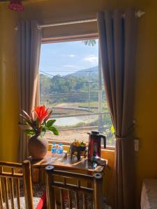 a table with a vase on it next to a window at Pu Luong Ecostay in Lũng Tiềm