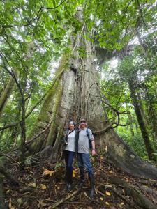een man en een vrouw die voor een boom staan bij capybara tours and lodge in San Pedro