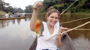 een vrouw die een vis vasthoudt in een boot bij capybara tours and lodge in San Pedro +6 foto's