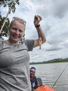 een vrouw die een stuk eten vasthoudt in een boot bij capybara tours and lodge in San Pedro