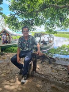 een man op een bank naast een kat bij capybara tours and lodge in San Pedro