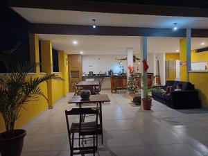 a living room with yellow walls and a table and chairs at Recanto Tucuns-Guest House in Búzios