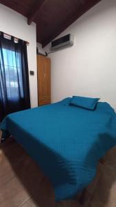 a blue bed in a room with a window at La Soñada in Miramar