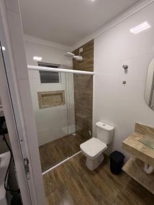 een badkamer met toilet en glazen douche bij Flats Privativos MaragoJulios in Maragogi +17 foto's