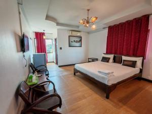 una camera con letto e tenda rossa di Erawan in a Mae Sot