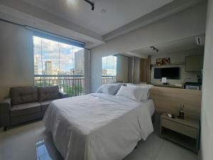 a bedroom with a large bed and a large window at Apartamento com Piscina no Rooftop in São Paulo