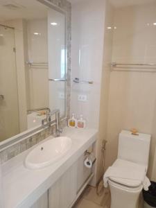 a white bathroom with a sink and a toilet at City Garden Olympus Condo By Vacation Vibes in Pattaya South +42 photos