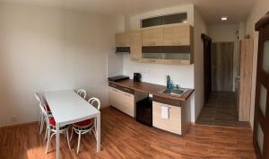 a small kitchen with a table and a table and chairs at Útulný apartmán v Jizerkách in Hejnice