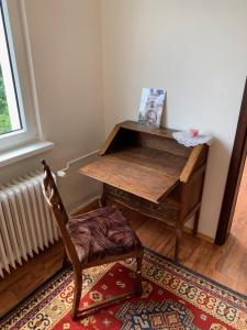 a desk in a room with a chair and a table at Útulný apartmán v Jizerkách in Hejnice