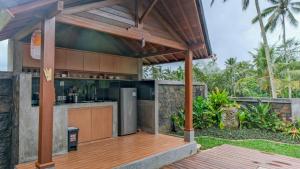 an outdoor kitchen with a wooden deck at Sanis House in Penginyahan