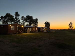 a group of lodges with the sunset in the background at CABAÑAS BRUTUS RANCHs in Azul +5 photos
