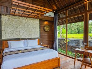 a bedroom with a bed and a large window at Sanis House in Penginyahan