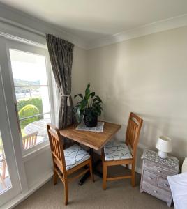 ein Raum mit einem Tisch und zwei Stühlen und einem Fenster in der Unterkunft Milberry House in Picton