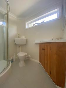 ein Badezimmer mit Toilette und Waschbecken und einem Fenster in der Unterkunft Milberry House in Picton