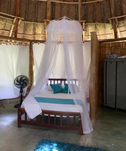 a bedroom with a bed with a canopy at Magic Green Dentro del Parque Tayrona in El Zaino