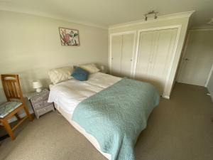 une chambre avec un lit avec une couverture bleue dans l'établissement Milberry House, à Picton