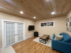 a living room with a blue couch and a tv at Cozy Cedar Nook in Hope