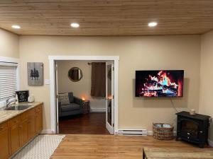 a living room with a fireplace and a tv on the wall at Cozy Cedar Nook in Hope