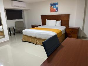 a hotel room with a bed and a desk at Hotel Frontera Baja in Mexicali