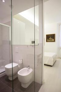 a bathroom with a sink and a toilet and a bed at Alberica10 in Carrara