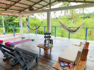a living room with a hammock and a room with a table at Cabin near the beach in El Valle