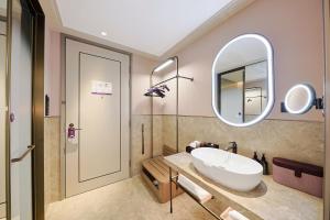 a bathroom with a sink and a mirror at Mercure Changbai Mountain North in Antu +67 photos