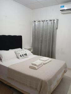 a bedroom with a bed with two towels on it at Casa Daia con cochera y piscina in Resistencia +12 photos