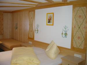ein Schlafzimmer mit einem weißen Bett und einem Sofa in der Unterkunft Ramsauer Sonnenalm in Ramsau am Dachstein