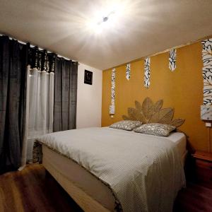 ein Schlafzimmer mit einem Bett mit Blättern an der Wand in der Unterkunft Apparemment Mawen in Tarbes + 4 Fotos