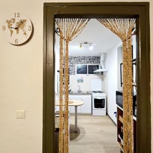 eine Küche mit einem Tisch und einer Uhr an der Wand in der Unterkunft Apparemment Mawen in Tarbes