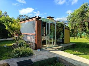 an old greenhouse is sitting in a garden at Eternal Sun in Balneario Buenos Aires +9 photos