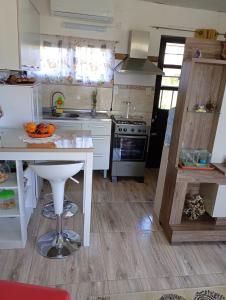 a kitchen with a white table and a stove at Eternal Sun in Balneario Buenos Aires