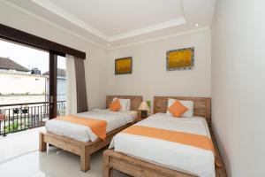 2 bedden in een kamer met een balkon bij Rumah Kultur in Ubud