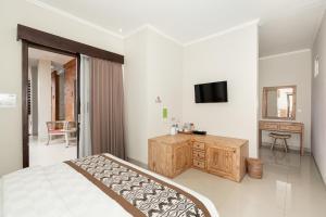 een slaapkamer met een bed en een televisie. bij Rumah Kultur in Ubud