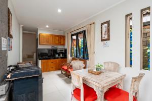 een keuken en eetkamer met een tafel en stoelen bij Rumah Kultur in Ubud