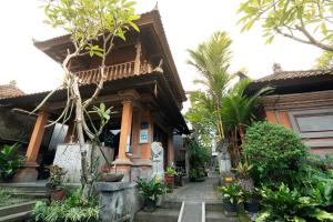 een huis met bomen en planten ervoor bij Rumah Kultur in Ubud