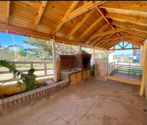 a large outdoor kitchen in a building with a wooden ceiling at El tabo house in El Tabo +11 photos