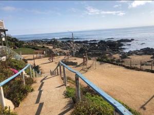 a staircase leading down to a beach with the ocean at El tabo house in El Tabo